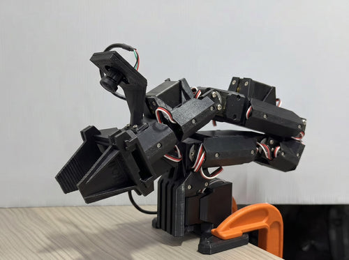 ElRobot 7+1 DoF 3D-printed robot arm in matte black PLA, clamped to a desk